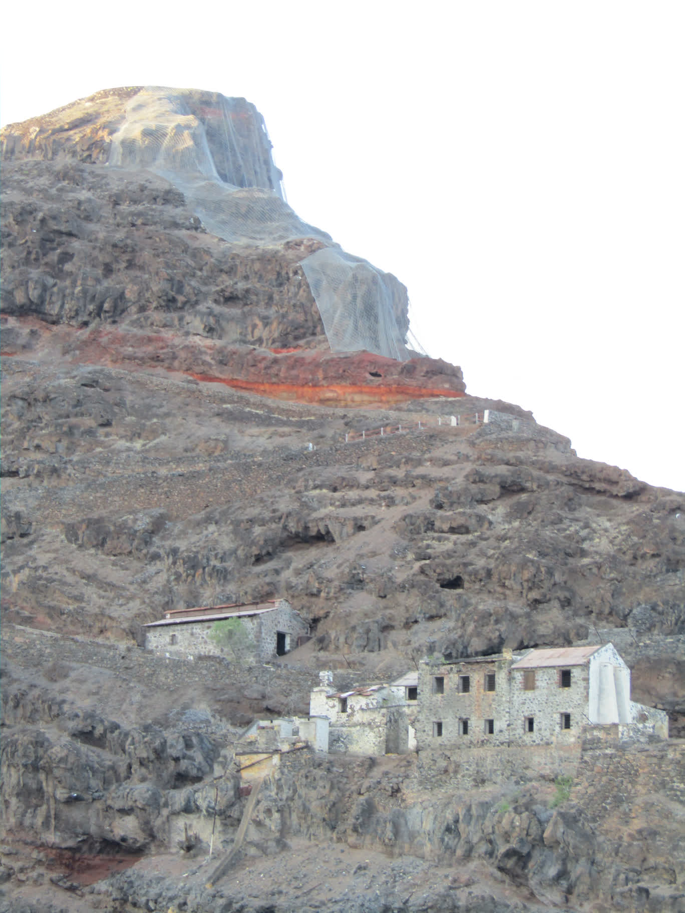 Old buildings on Munden's Point overlooking James Bay. The cliffs were covered in cyclone fencing to prevent rocks from tumbling down onto the buildings and people below