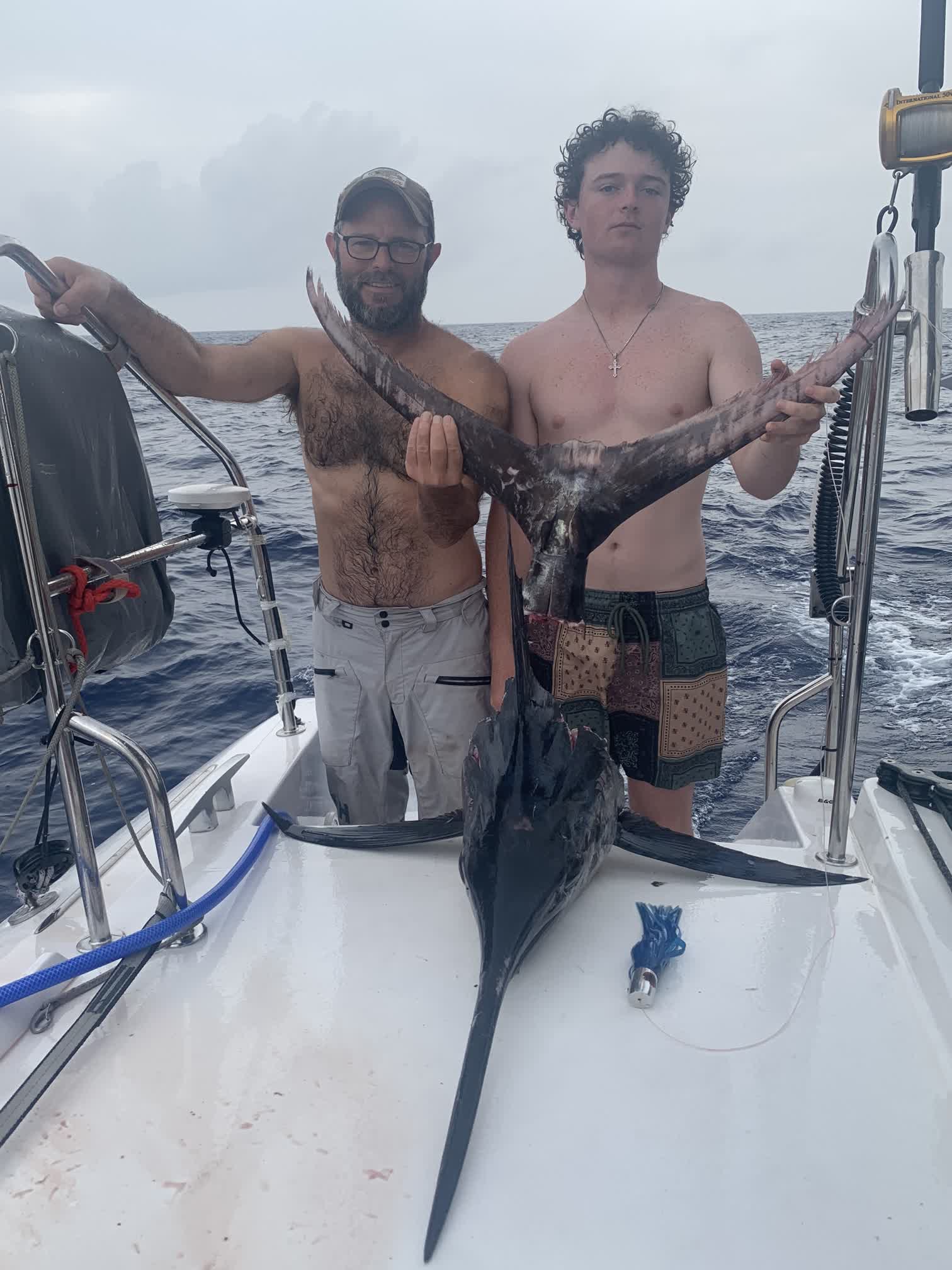 Dan and Auden with the head and tail of the marlin after it had been cut up for meat